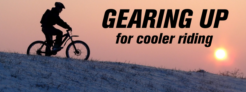 Man riding a bike over a hill from a silhouetted angle at sunset, text "Gearing up for Cooler Riding"