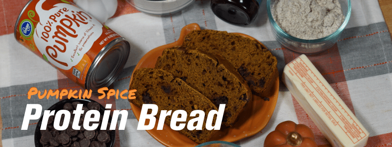 Pumpkin spice protein bread on table surrounded by the requisite ingredients, text "Pumpkin Spice Protein Bread"