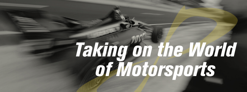 Race car driving by quickly, text "taking on the World of Motorsports"