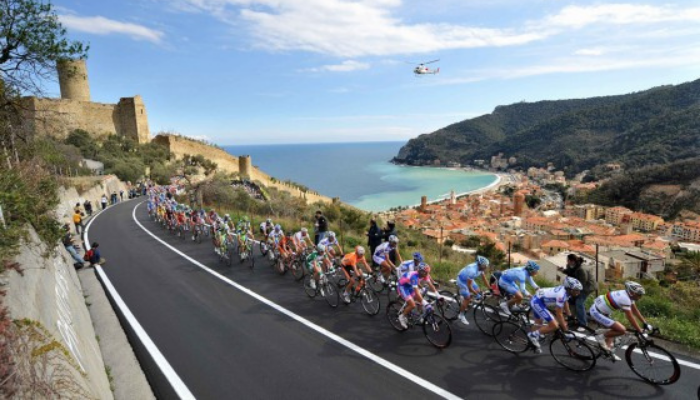 group bike racing along a coastal road