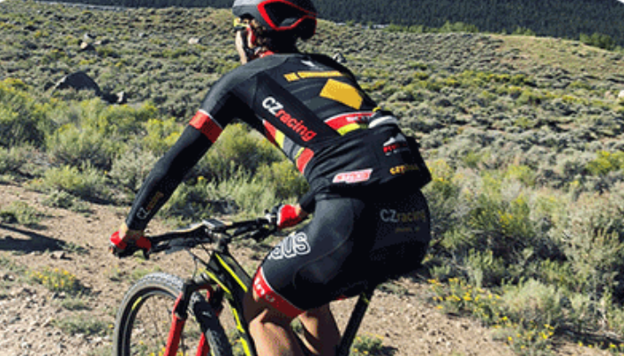 Ryan Petry riding bike through desert from the back