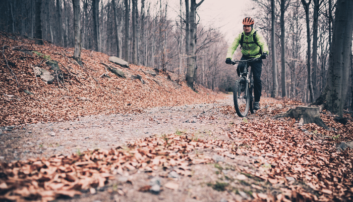 Man riding bike through woods on a fall day